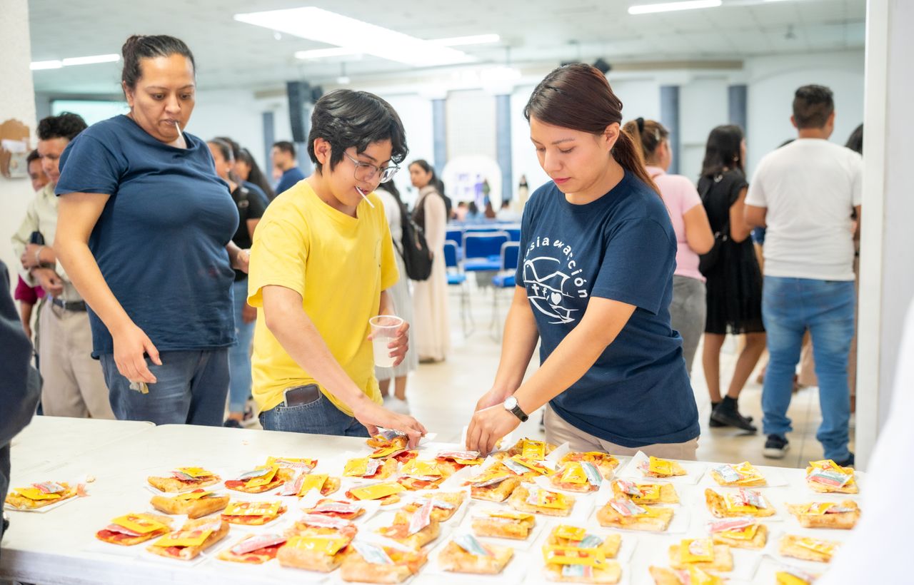 People gathering and serving food at an event in Ciudad de México, CDMX.