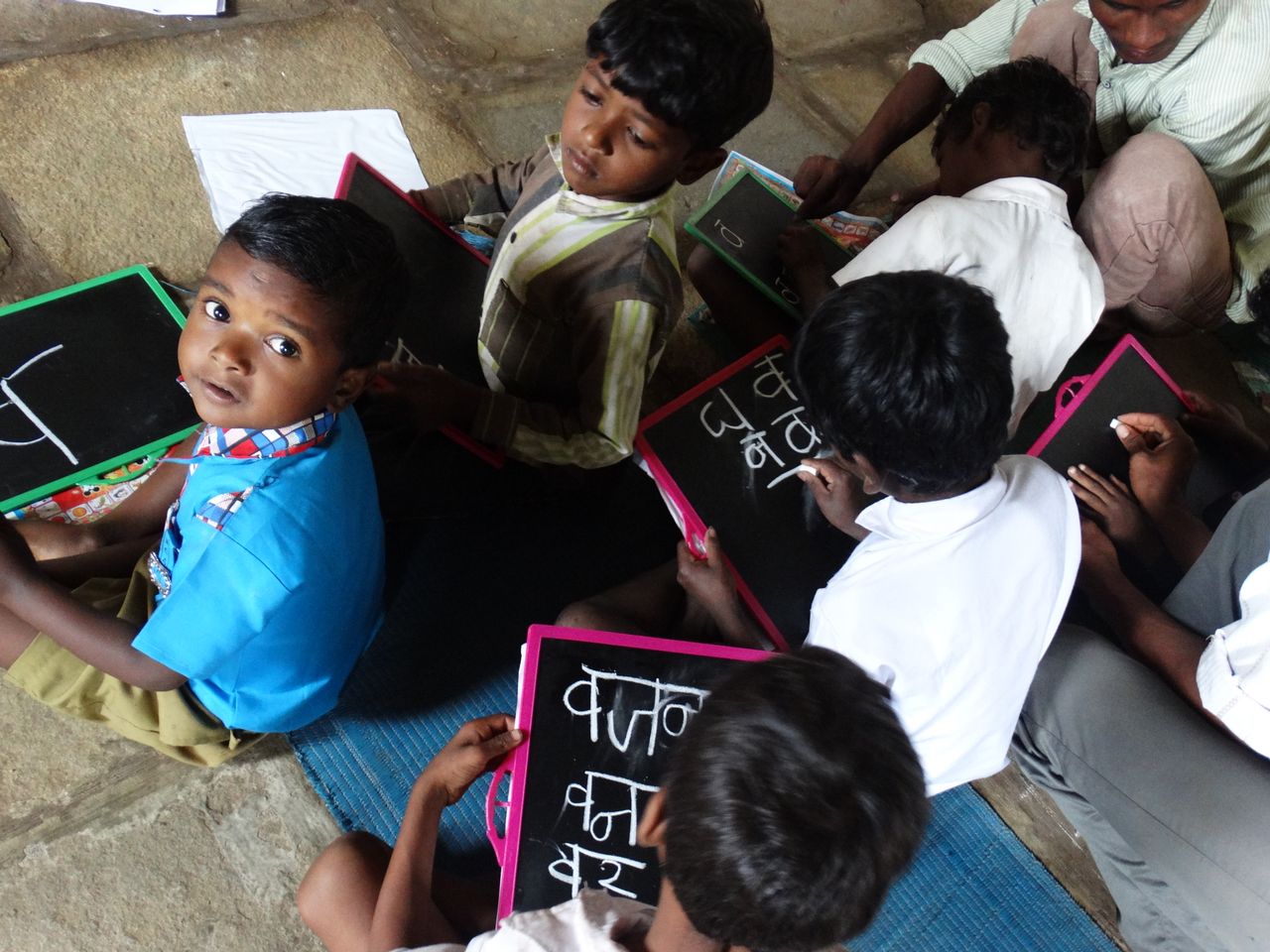 about-us Young students writing on slates in a village school in Melghat, India.